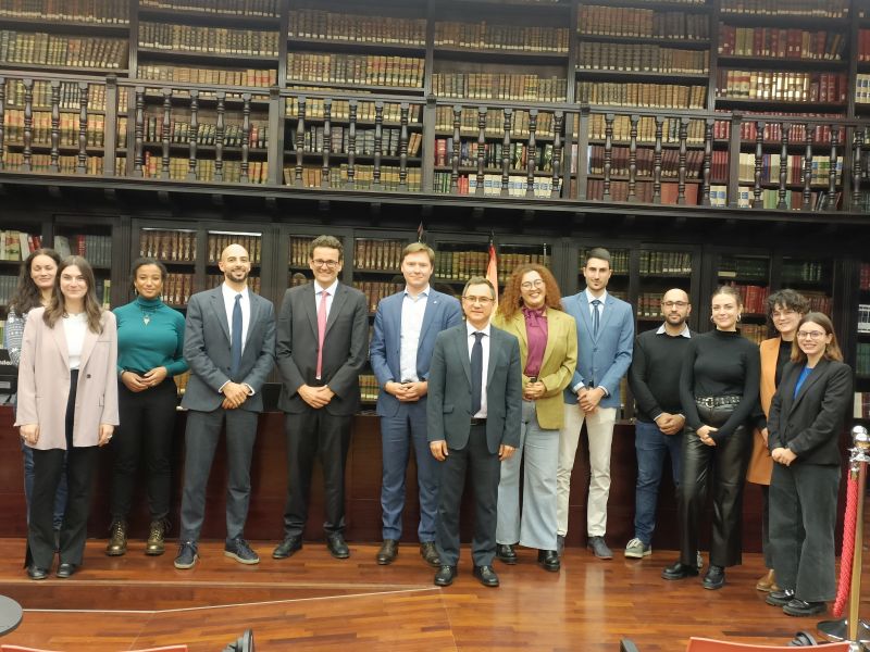 Josephine, third from the left, smiles with fellow participants in front of an imposing library.