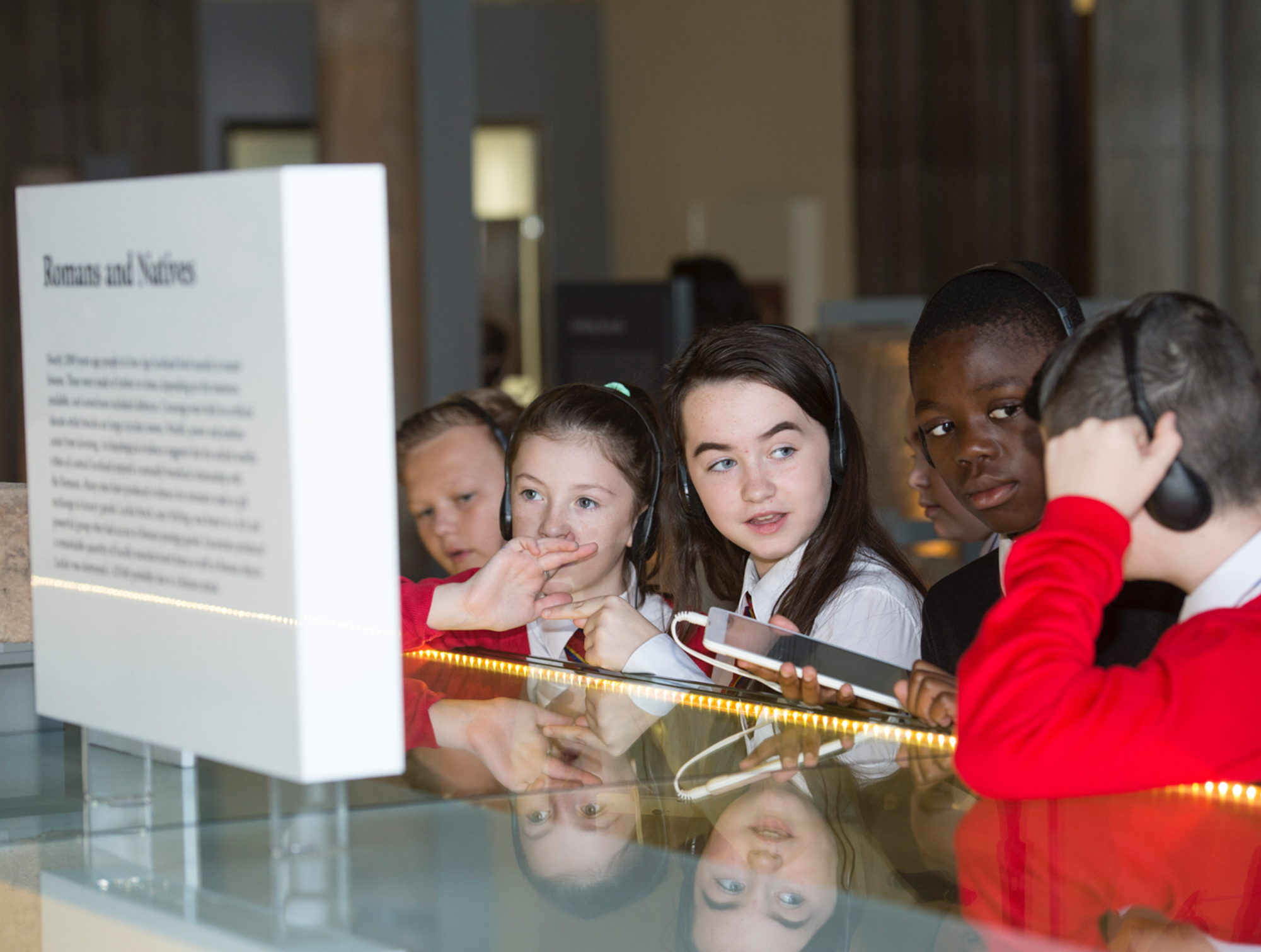 Group of children listening to a museum audio guide